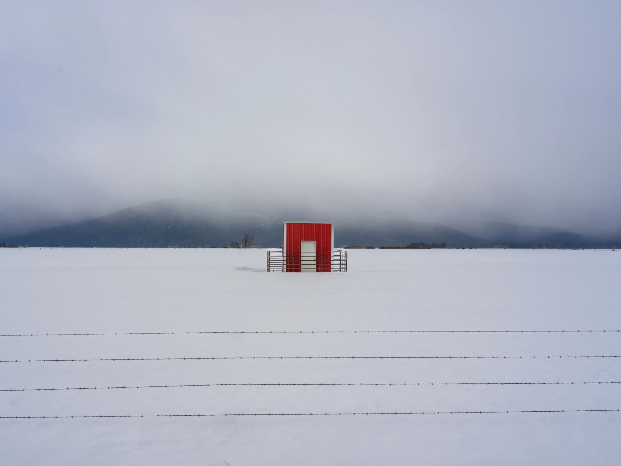 Red cabin in a vast snowy landscape